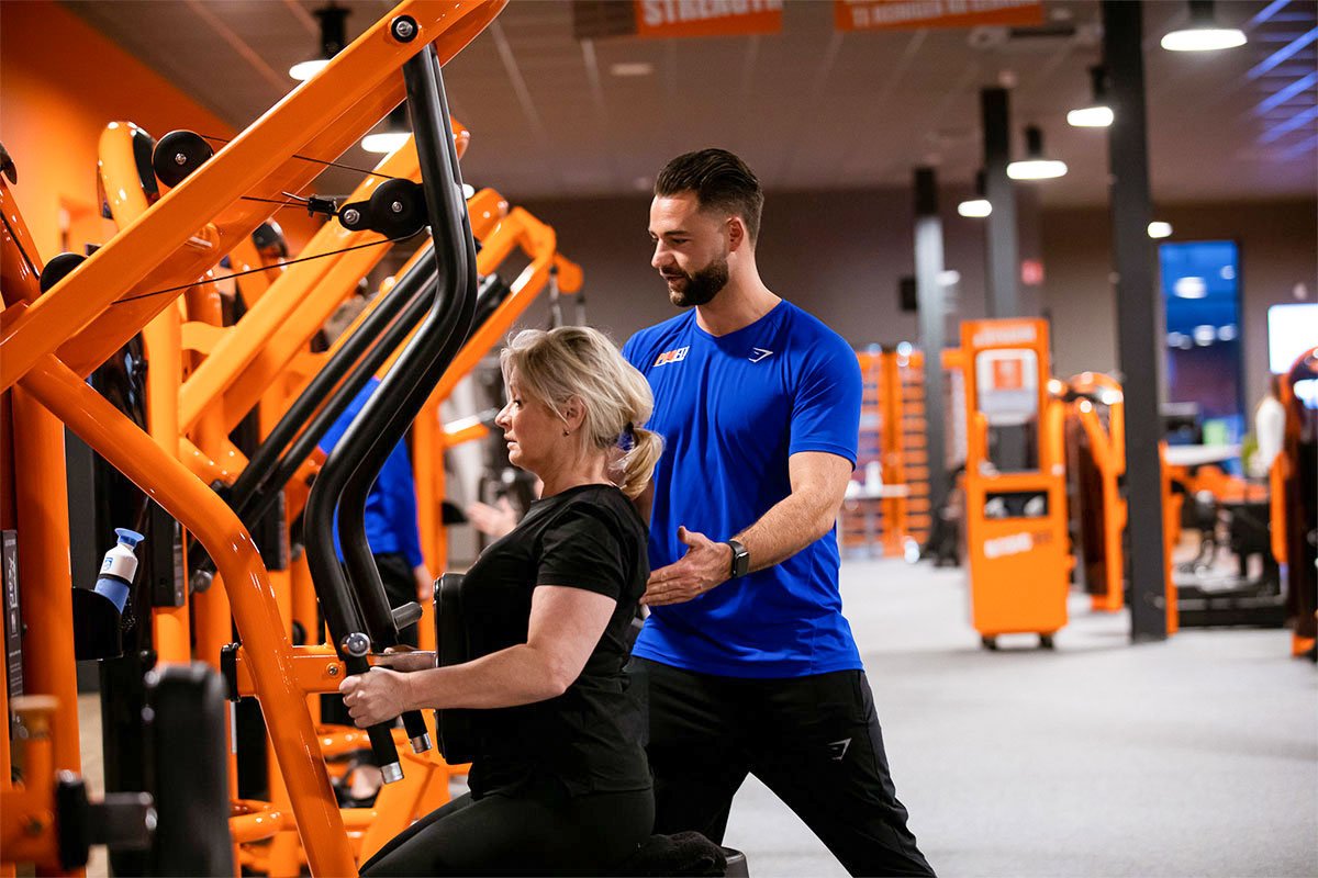 A Pro Fit coach guiding a client on a machine