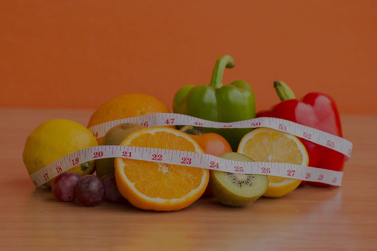Fresh fruit and vegetables with a measuring tape